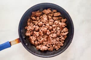 Browned ground beef in a skillet.
