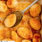 Golden potatoes and a serving spoon in a baking dish.