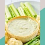 A bowl of green goddess dip and vegetables around it.