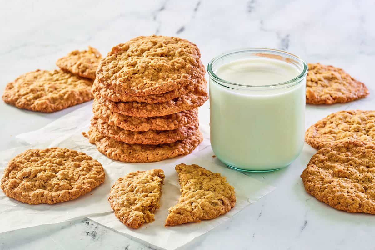 Potato chip cookies in a stack next to a glass of milk.