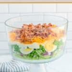 Old-fashioned seven layer salad in a trifle dish.