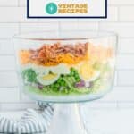Traditional seven layer salad in a trifle dish.