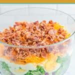 Seven layer salad in a glass trifle bowl.