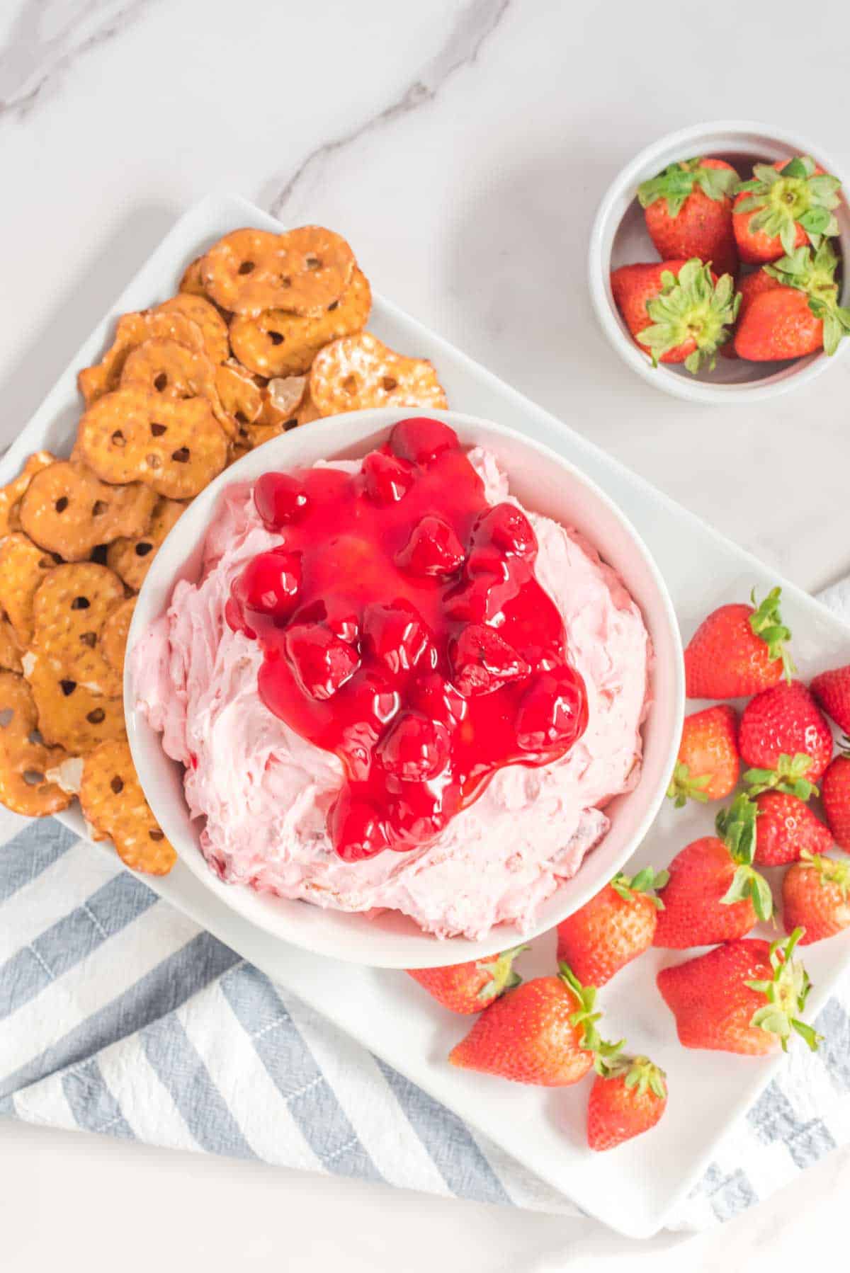 Overhead view of strawberry pretzel dip, pretzel chips, and strawberries on a platter.