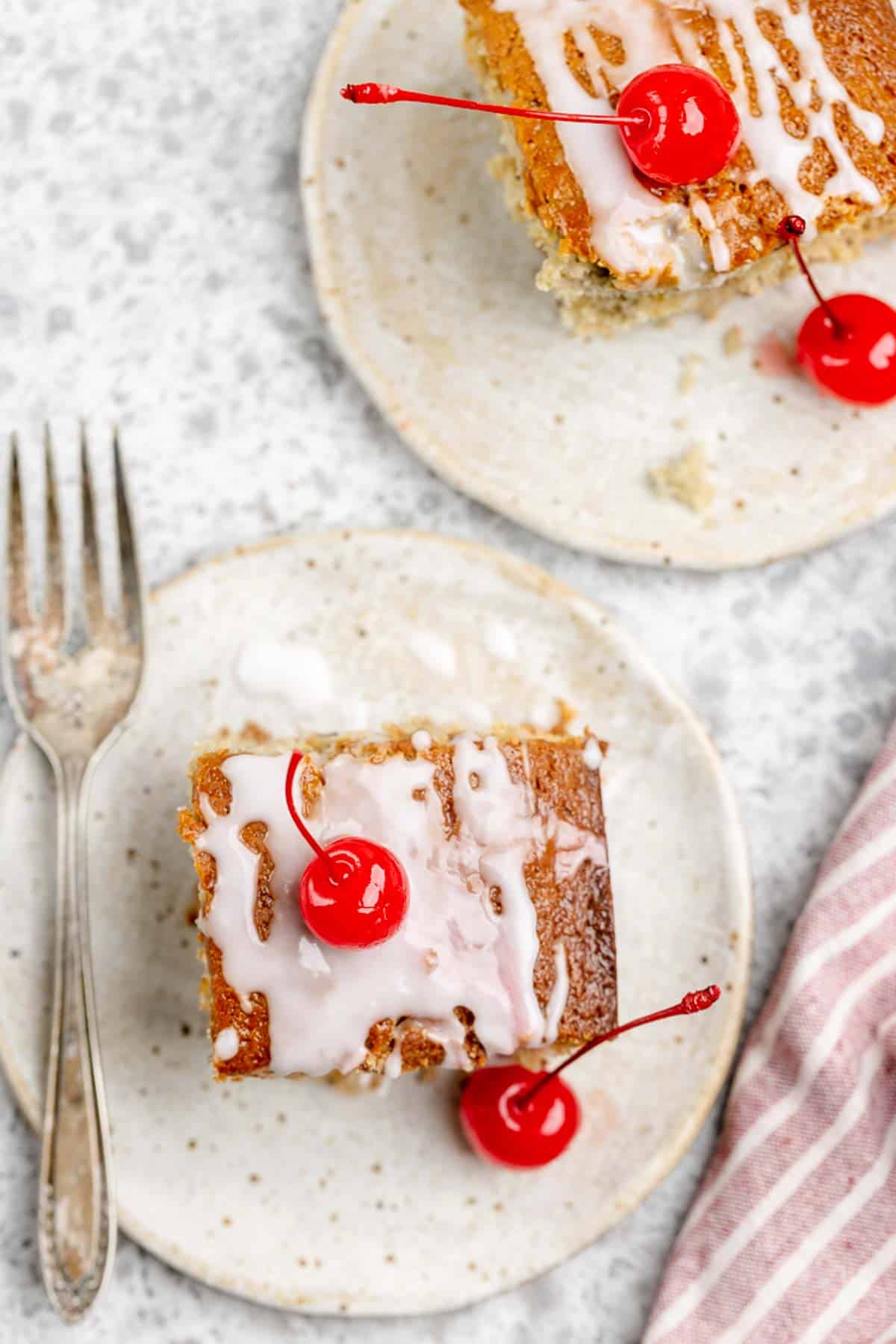 Overhead view of sour cream cherry coffee cake slices on plates.