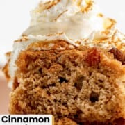 Cinnamon pudding cake with pecans topped with a dollop of whipped cream.
