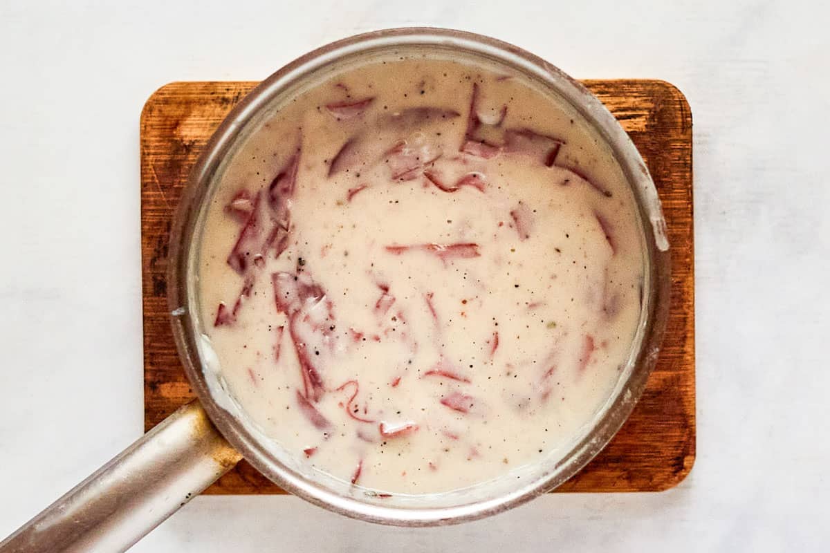 Creamed chipped beef in a saucepan.