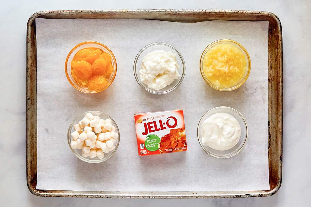Orange cottage cheese Jello salad ingredients on a tray.
