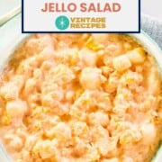 Orange Jello salad with cottage cheese and marshmallows in a bowl.
