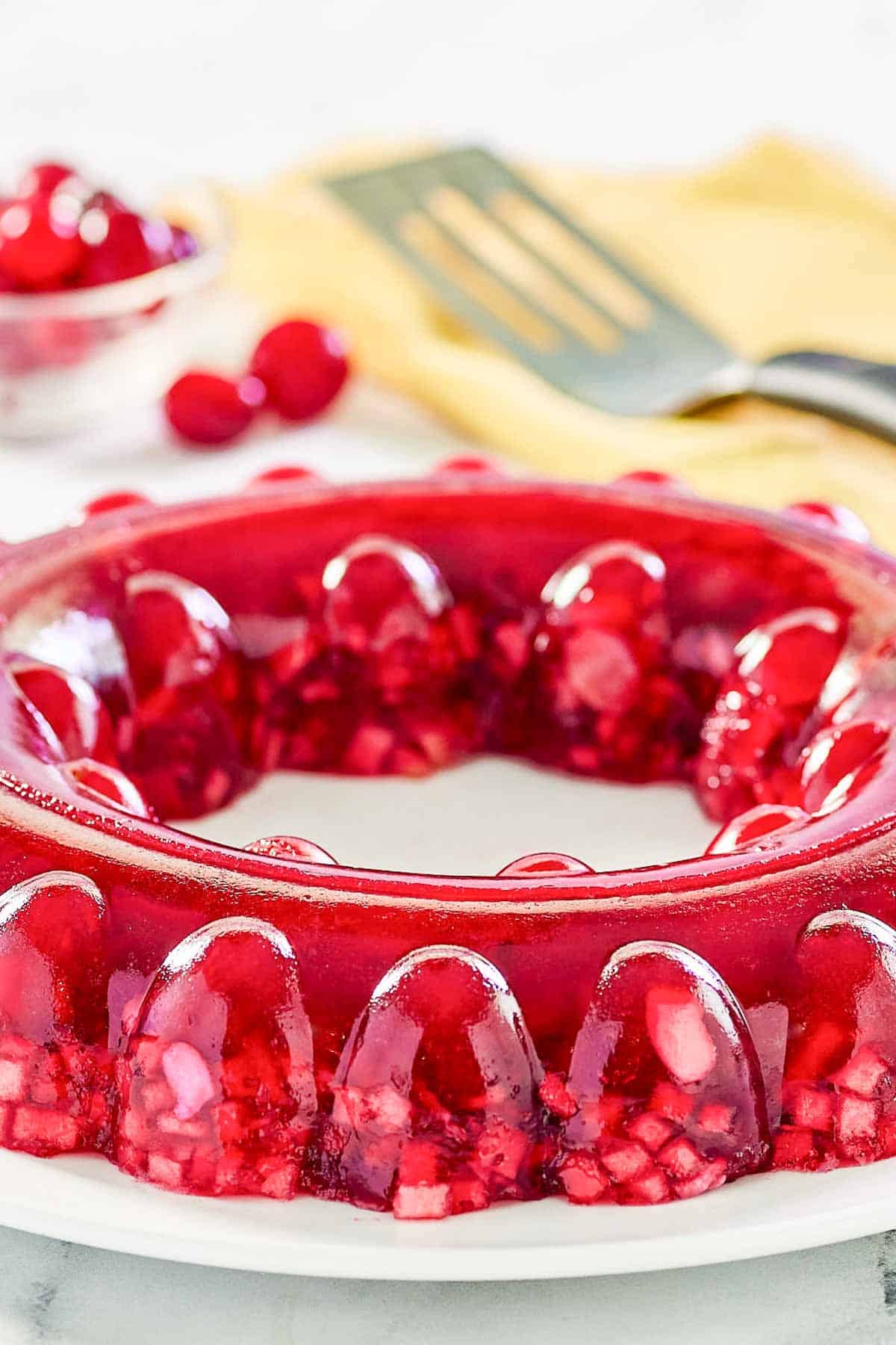 Cranberry jello salad with apples, celery, and nuts on a large round platter.