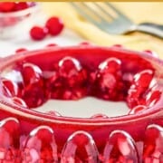 Cranberry jello salad made with apples, nuts, and celery on a platter.