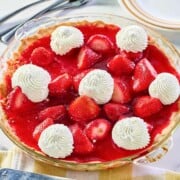 Old fashioned strawberry pie garnished with whipped cream.