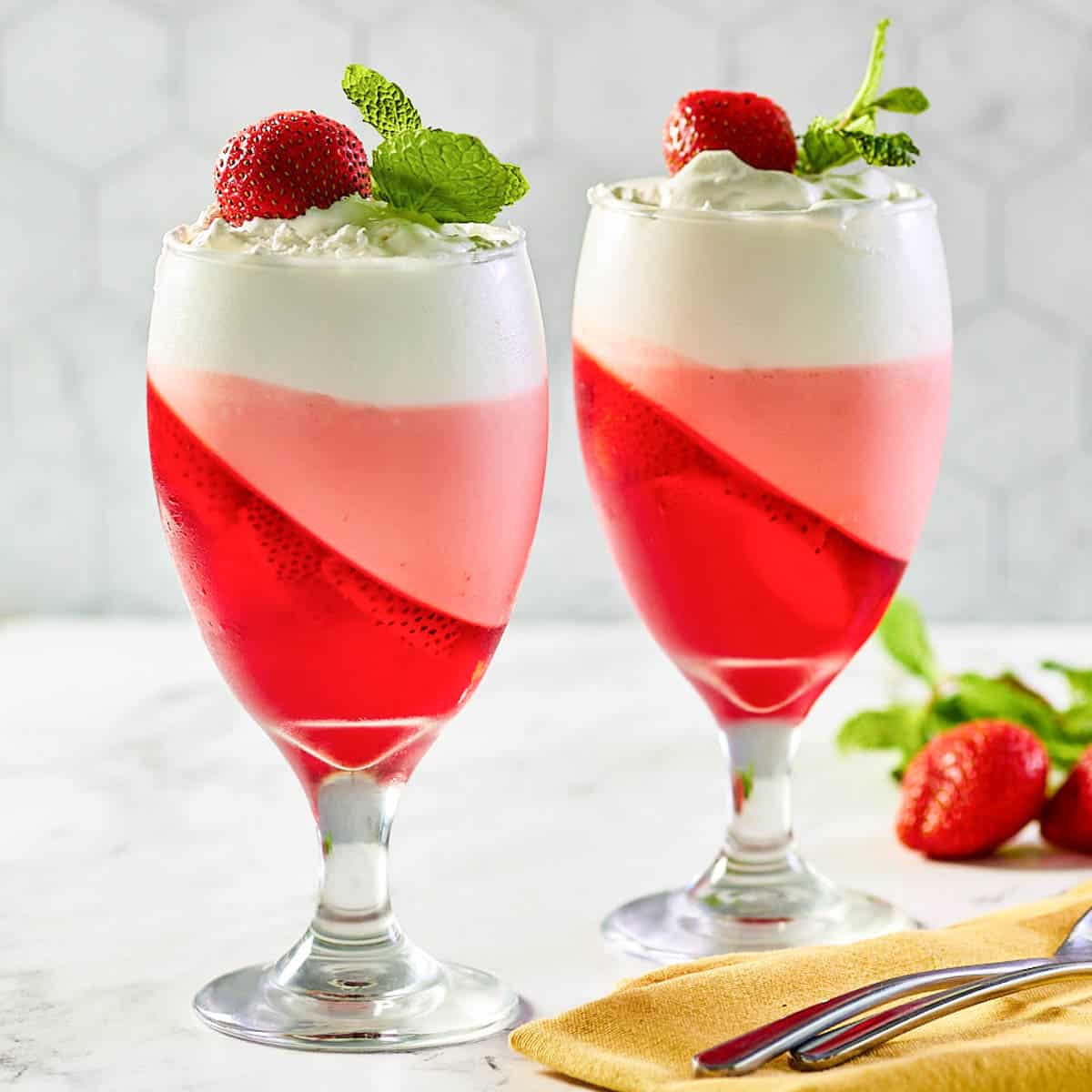 Strawberry jello parfait in two glasses.