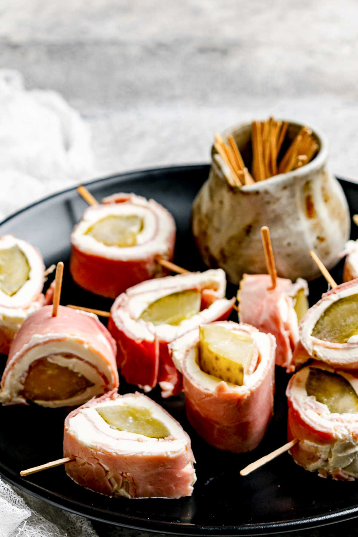 Ham and pickle roll ups on a platter.