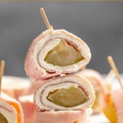Two ham and pickle roll ups stacked on top of one on its side.