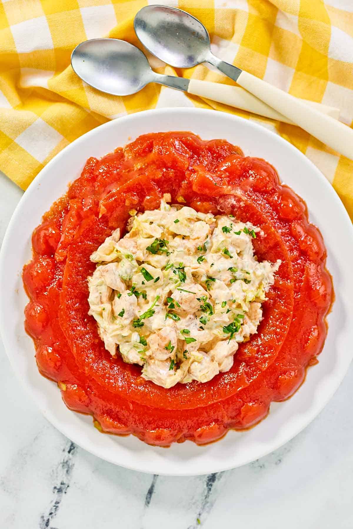 Tomato aspic made in a round jello ring mold with shrimp salad in the center.