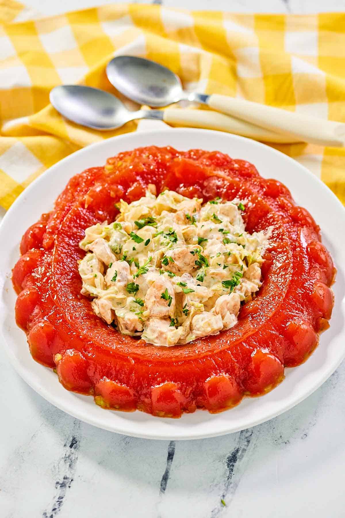 Tomato aspic with shrimp salad in the center on a large round platter.