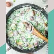 Creamed peas and potatoes and a wooden spoon in a skillet.