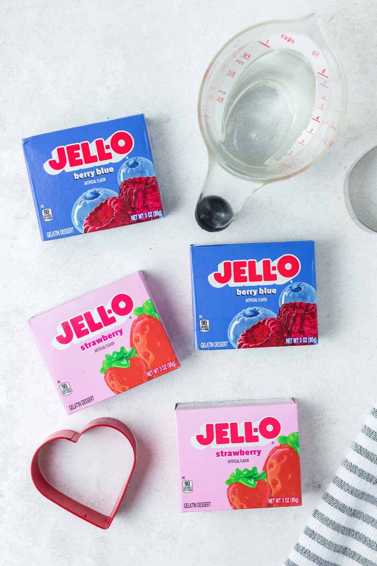 Jello jigglers ingredients on a marble surface.