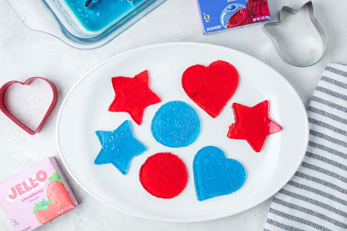 Jello jigglers on a plate, cookie cutters, and boxes of Jello.